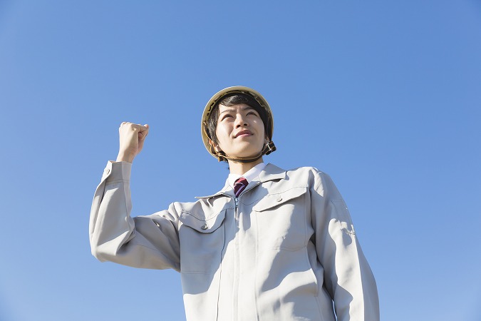 空を見上げガッツポーズをするスタッフ
